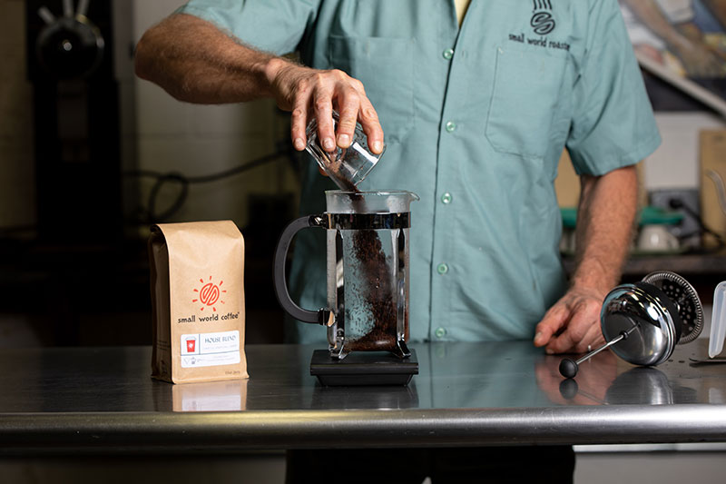Empty the preheating water from the press, and add ground coffee to press.